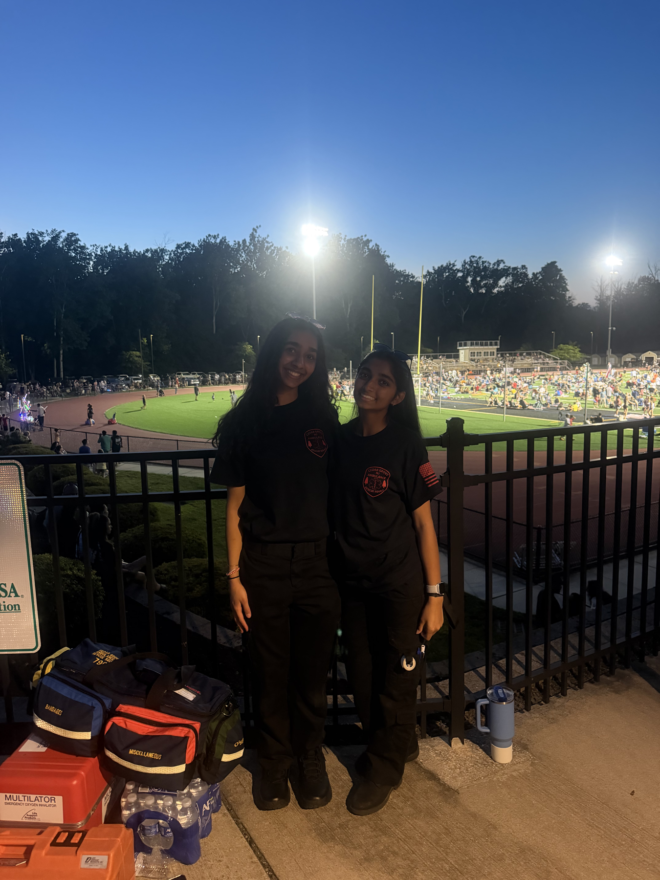 Two Cedar Grove EMS members at a Fourth of July community standby overlooking the field