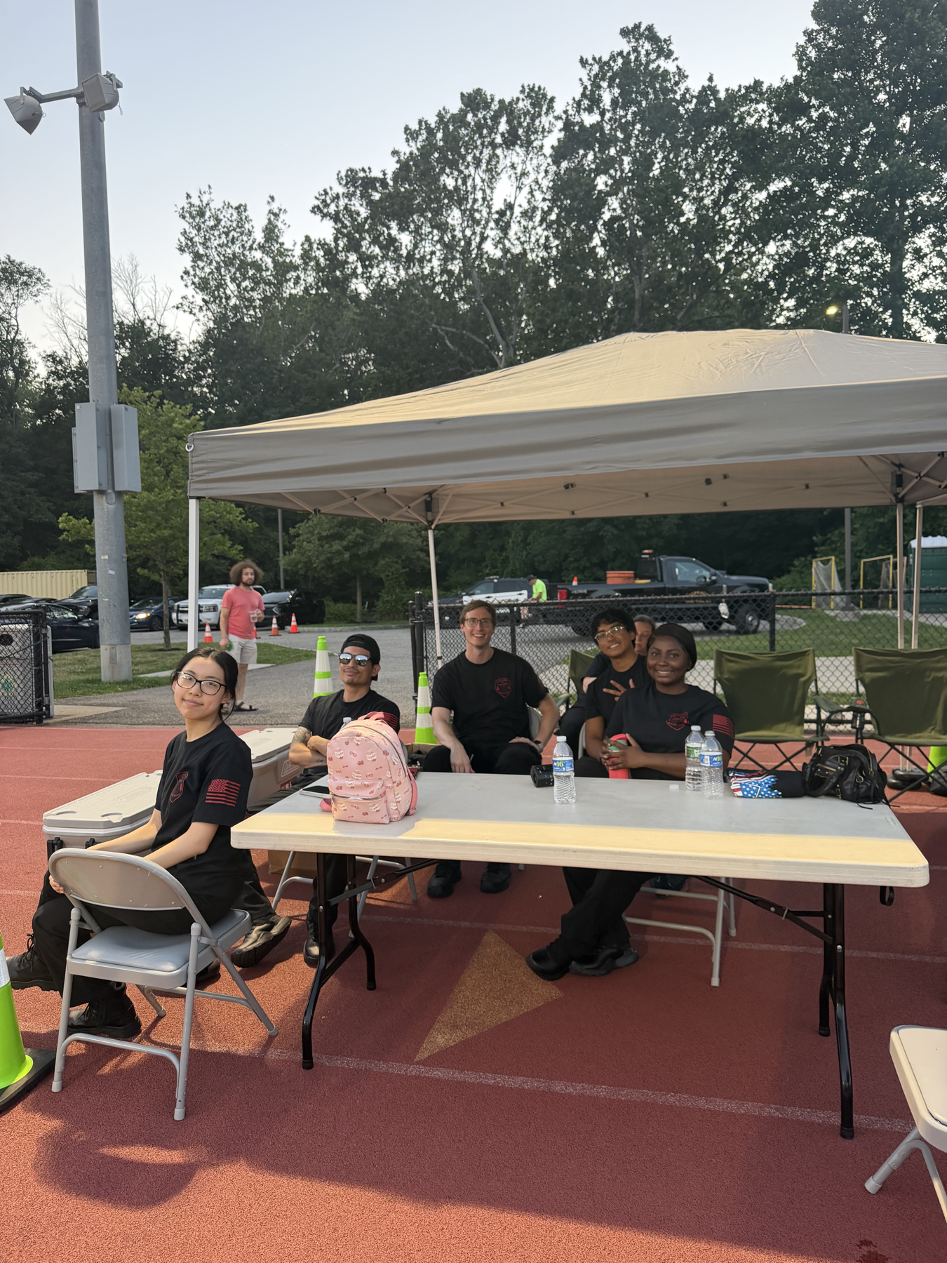 Cedar Grove EMS members seated at a community standby table under a canopy