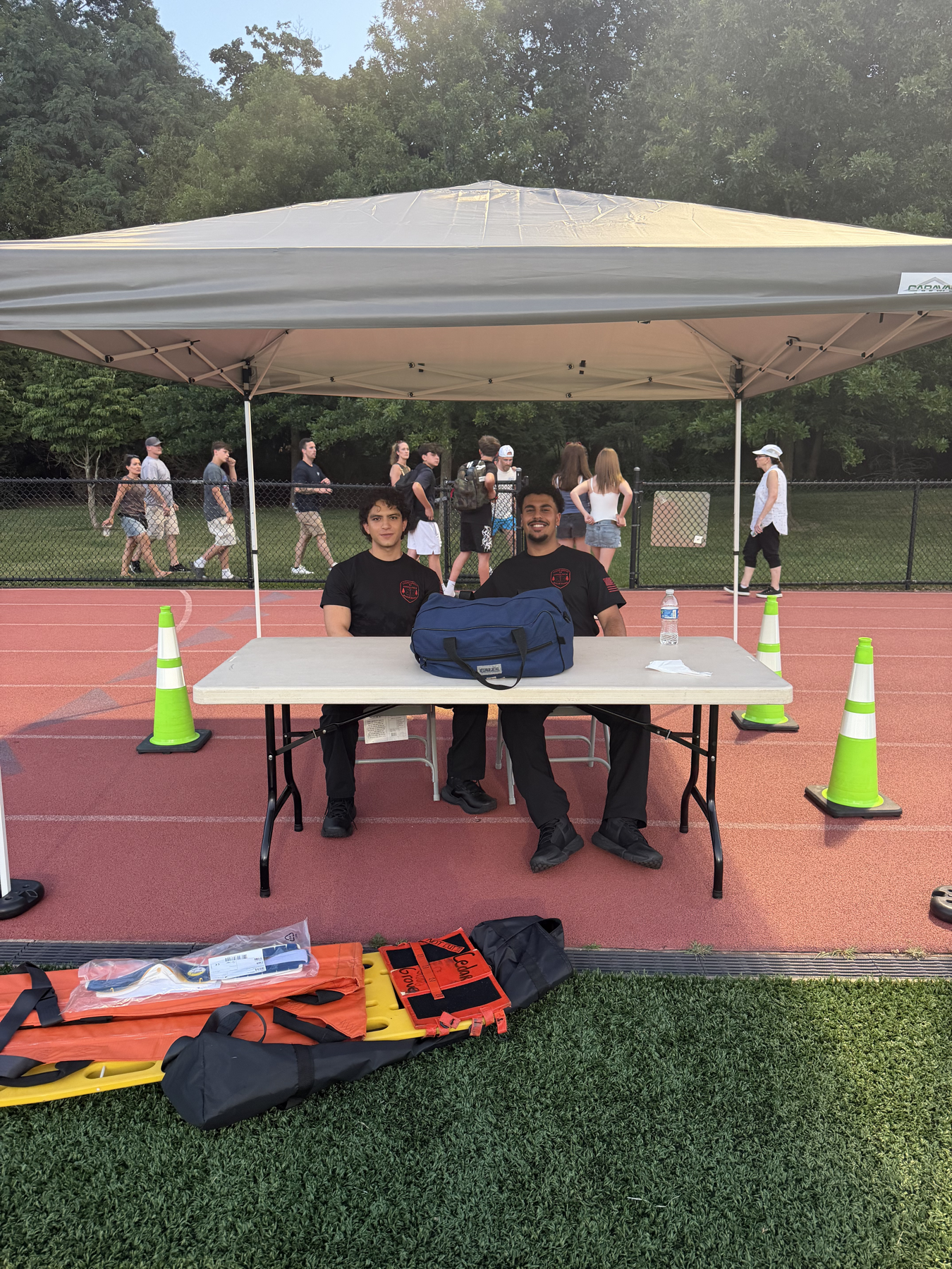 Two Cedar Grove EMS members seated at a community standby table